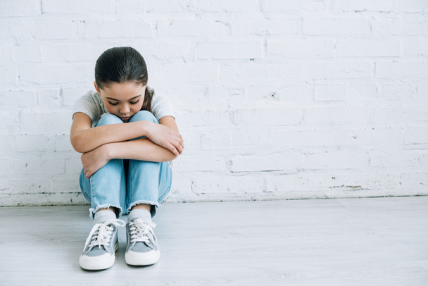 upset preteen child sitting on floor at home - Photo, Image