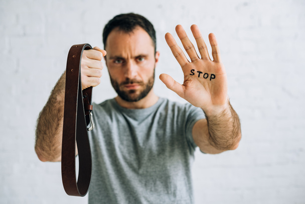 Selektiver Fokus des Vaters zeigt Gürtel und Schriftzug Stop auf Handfläche - Foto, Bild