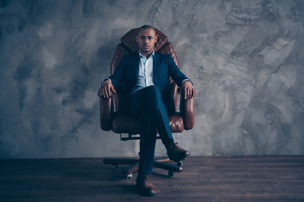 Portrait serious focused chairman boss executive manger cool confident sit brown furniture dream dreamy short hair bald entrepreneur crossed legs wear jackets trousers shoes isolated grey background - Photo, Image
