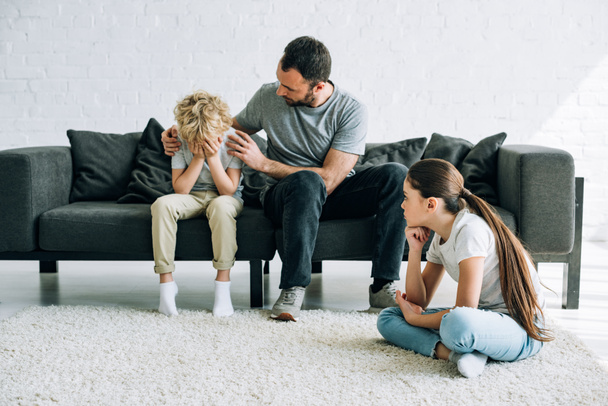 two sad preteen children and father having conflict - Foto, afbeelding