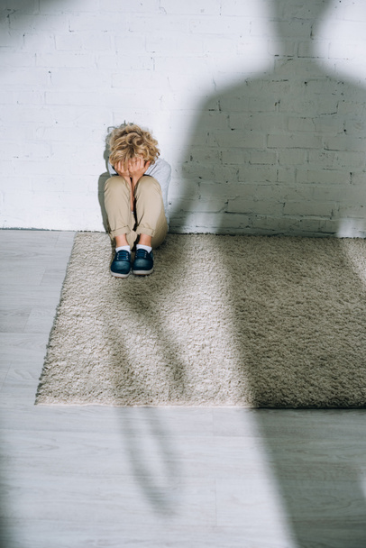 silhouette and scared little boy sitting on carpet - Foto, Imagem