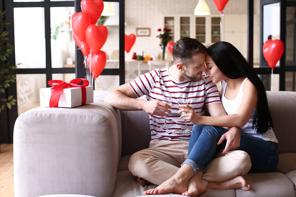 Feliz joven pareja bebiendo champán en casa el día de San Valentín
 - Foto, imagen