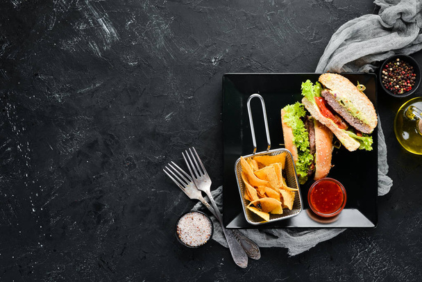 Burger with meat and snacks nachos. In the plate. Top view. Free space for your text. Rustic style. - Фото, изображение