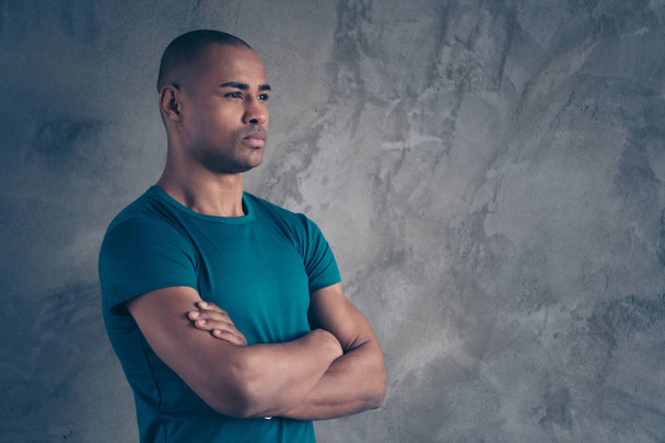 Profile side view portrait of his he nice-looking attractive strong powerful content dreamy guy wearing trendy blue t-shirt folded arms isolated over gray industrial concrete wall - Фото, зображення