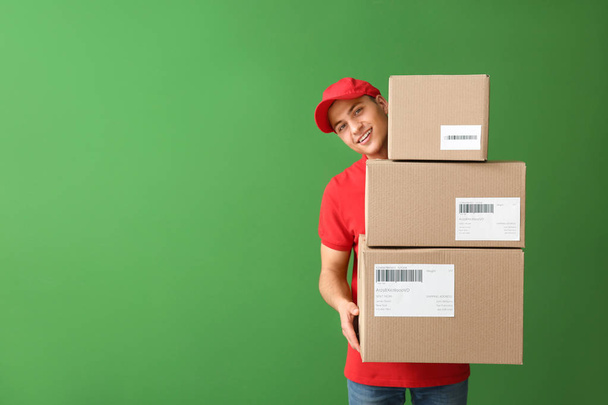 Delivery man with boxes on color background - Photo, Image