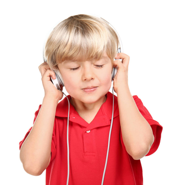 Cute little boy listening to music on white background - Photo, image