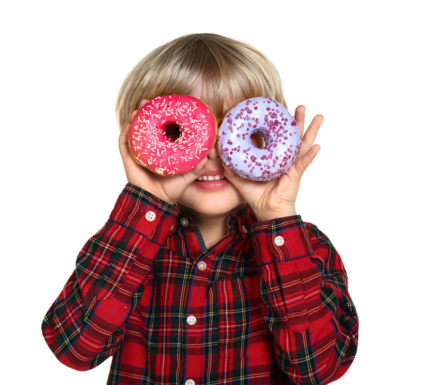 Happy little boy with tasty donuts on white background - Photo, Image