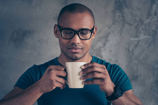 Close up photo amazing he him his dark skin macho handsome hand arm hold raise hot beverage have minute delicious cappuccino office working day wear specs casual blue t-shirt isolated grey background - Foto, immagini