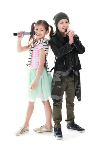 Χαριτωμένα μικρά τραγουδίστριες με μικρόφωνα σε λευκό φόντο - Φωτογραφία, εικόνα