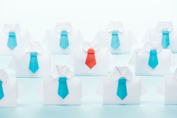 origami white shirts with blue ties with one red on blue background, think different concept - 写真・画像