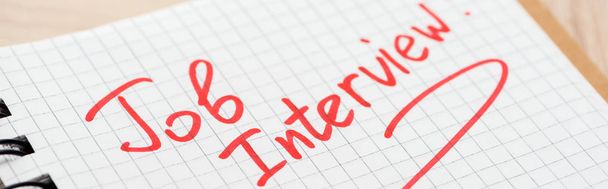 panoramic shot of notebook with job interview red lettering  - Foto, Bild