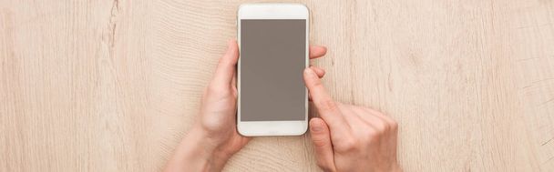 panoramic shot of woman holding smartphone with blank screen - Foto, Imagen
