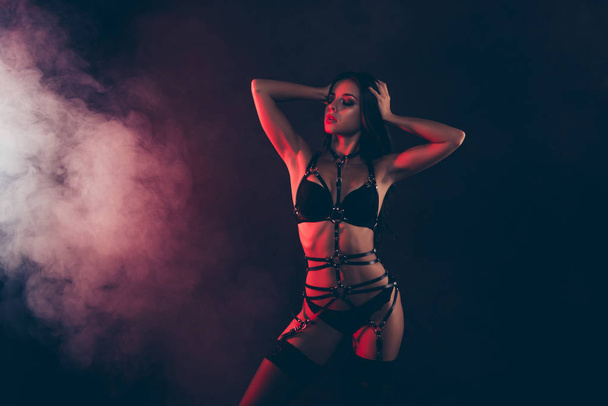 Portrait of nice cool gorgeous winsome attractive sportive perfect thin fit form shape line wavy-haired lady wearing swordbelt teasing posing isolated on black red light background - Φωτογραφία, εικόνα
