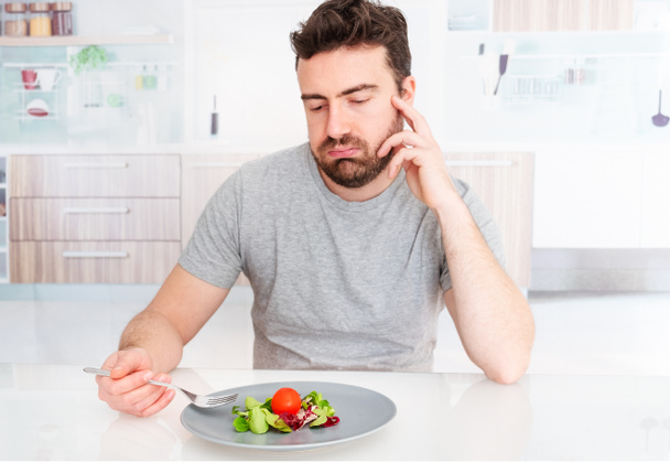 Sad man forced to eat salad for weight loss - Photo, Image