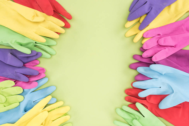 top view of multicolored rubber gloves on green background with copy space - Valokuva, kuva