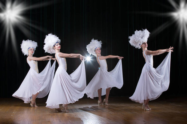 Kabaree. Tytöt tanssivat varietee-ohjelmaa. Tanssijat valkoisissa mekoissa suorittavat modernia tanssikabareettia
 - Valokuva, kuva