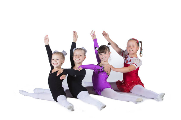Meisjes gymnasten op een witte achtergrond. Vier kleine acrobaten op de snaar. - Foto, afbeelding