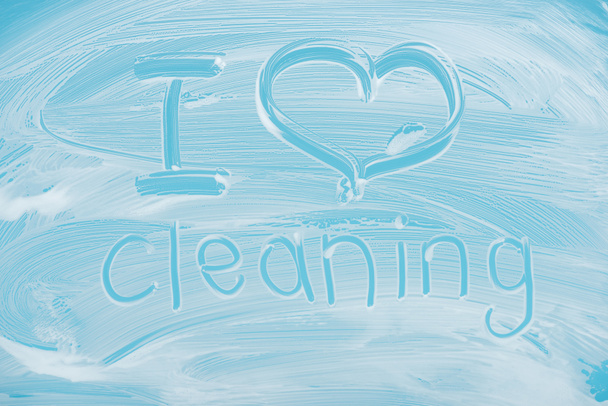Imádom takarítás kézírással betűkkel írt üveg, fehér hab a kék háttér - Fotó, kép