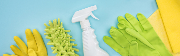 panoramic shot of cleaning supplies on blue background - Foto, afbeelding