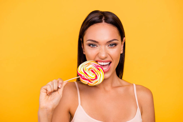 Close up photo beautiful she her lady you not you when hungry addicted sweets person big lolly pop wooden stick rude behavior biting wear casual pastel tank-top isolated yellow bright background - Photo, Image