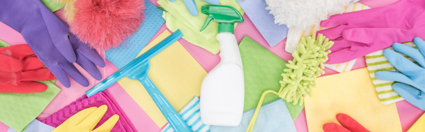 panoramic shot of messy scattered multicolored cleaning supplies on pink background - Photo, Image