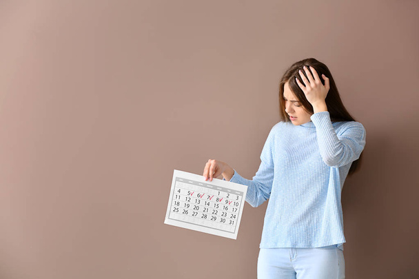 Femme stressée avec calendrier sur fond de couleur
 - Photo, image