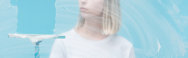 Panoramaaufnahme einer jungen Frau, die Glas mit Rakel auf blauem Hintergrund lehnt - Foto, Bild
