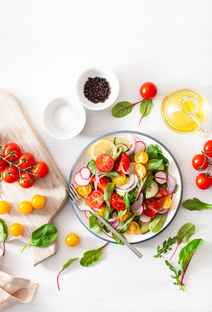 カラフルな菜食主義者の健康的なトマトのサラダ キュウリ、大根、玉ねぎ - 写真・画像