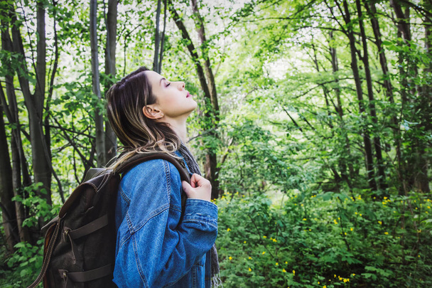 Jeune femme avec sac à dos dans une forêt mixte
 - Photo, image