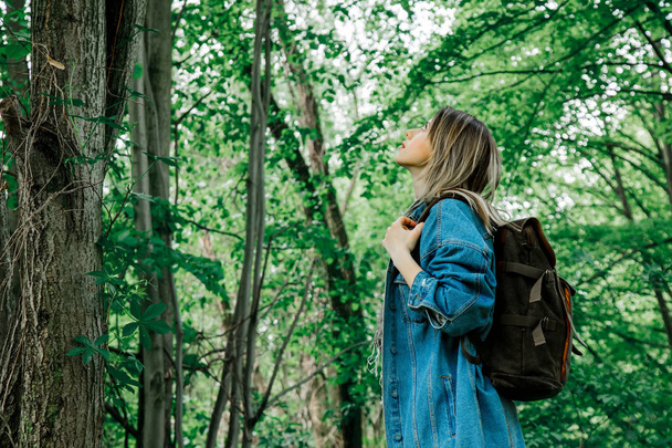 Fiatal nő hátizsákkal egy vegyes erdőben - Fotó, kép