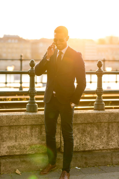 A businessman next to a tramline talking on his phone - Zdjęcie, obraz