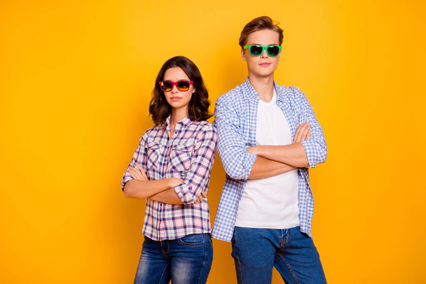 Close up photo of pair in summer specs he him his she her lady boy hands crossed standing back to back self-confident examiners wearing casual plaid shirts outfit isolated on yellow background - Fotografie, Obrázek