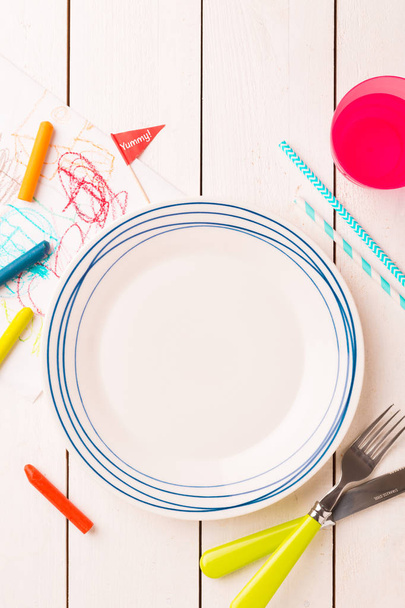 Table setting for kids - empty plate with decorations around - Foto, imagen
