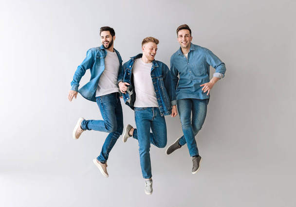 Jumping young men on light background - Foto, Bild