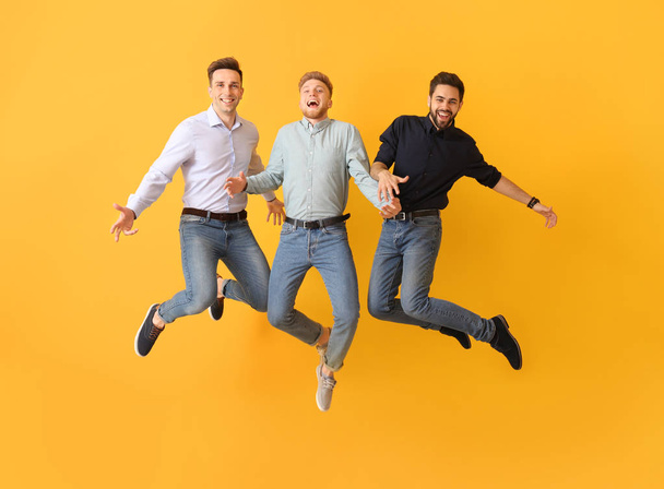 Jumping young men on color background - Photo, Image