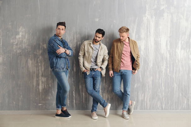 Fashionable young men near grey wall - Photo, Image