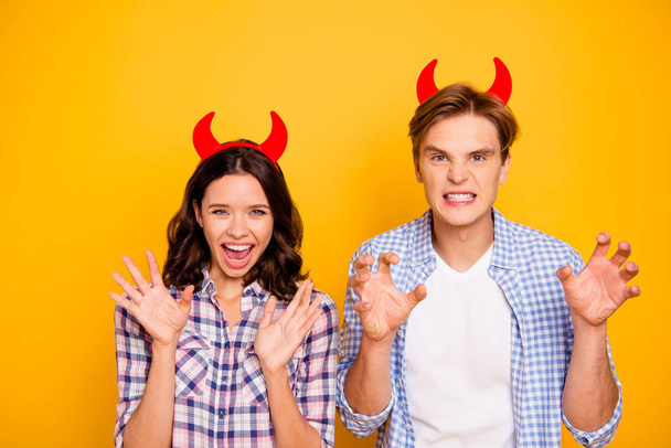 Close up photo of pair in love he him his she her lady boy ready for halloween party put red horns on head playing devils wearing casual plaid shirts outfit isolated on yellow background - Photo, image