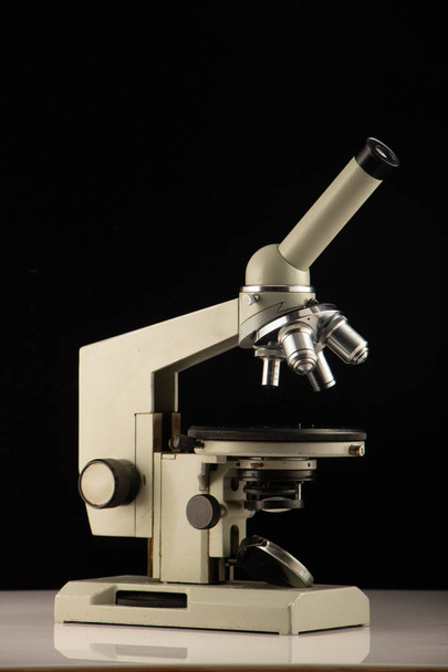 microscopio blanco sobre fondo oscuro. De cerca.
 - Foto, Imagen