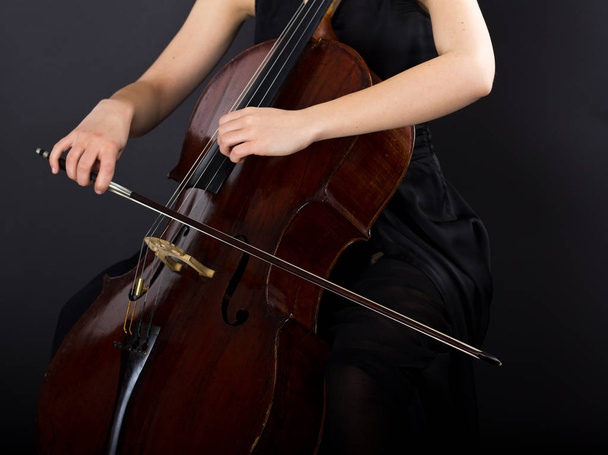 Giovane ragazza che suona il violoncello al buio. Cellulare
 - Foto, immagini