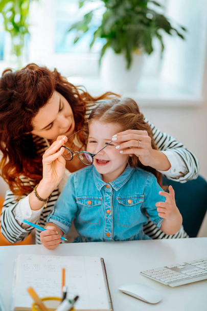 Red-haired mother putting her glasses on little cute daughter - Fotografie, Obrázek