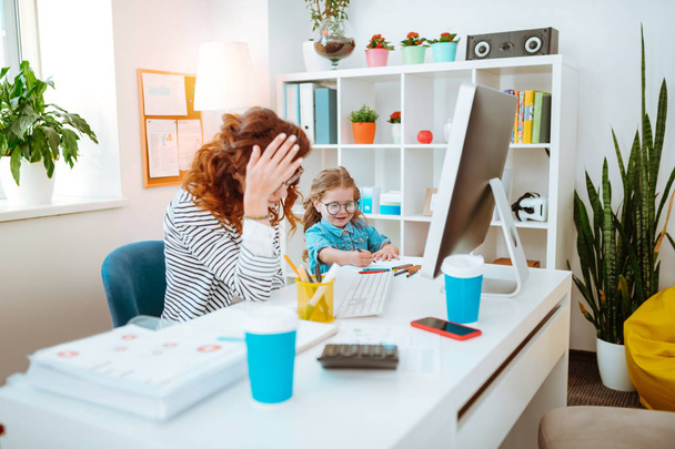 Mom having too much work while sitting near daughter - Photo, image