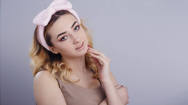portrait of a beautiful girl woman in a headband for make up on studio background, concept of beauty, advertising cosmetics, body care - 写真・画像