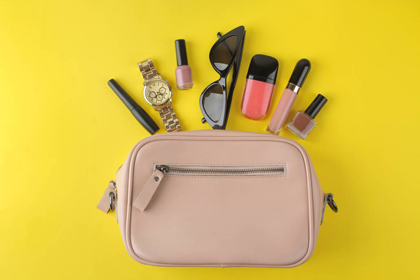 Stylová růžová taška a dámská kosmetika a doplňky na jasně módním žlutém pozadí. pojetí ženských příslušenství. pohled shora - Fotografie, Obrázek