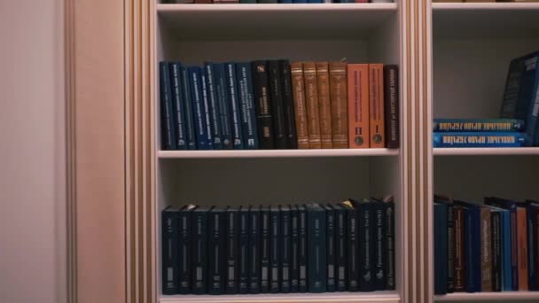 Półka na książki w bibliotece domowej. Wiele książek na półce - Materiał filmowy, wideo