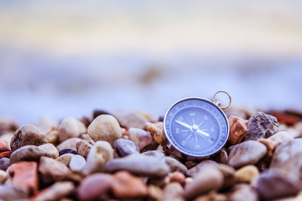 Navigation concept: Compass is lying on the beach near the sea - Photo, Image