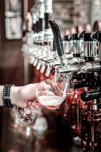 Filling the glass with lager from the beer tap. - Foto, Imagen