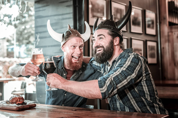 Two friends wearing viking helmets and laughing. - 写真・画像