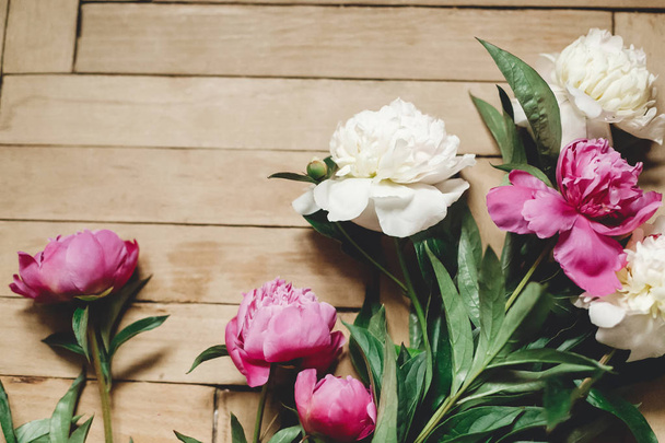Beautiful pink and white peonies on rustic wooden floor , flat l - Фото, изображение