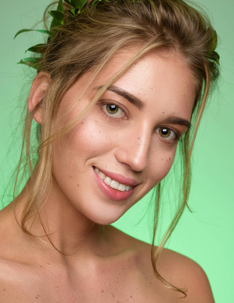 Retrato de beleza do rosto da mulher com sardas usa uma coroa de folhas verdes
 - Foto, Imagem