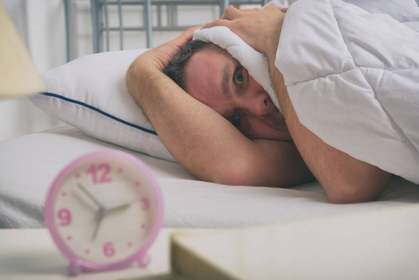 Slapeloze man in zijn bed - Foto, afbeelding